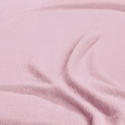 Nahaufnahme eines rosa Spannbetttuchs mit weicher Textur und Falten.