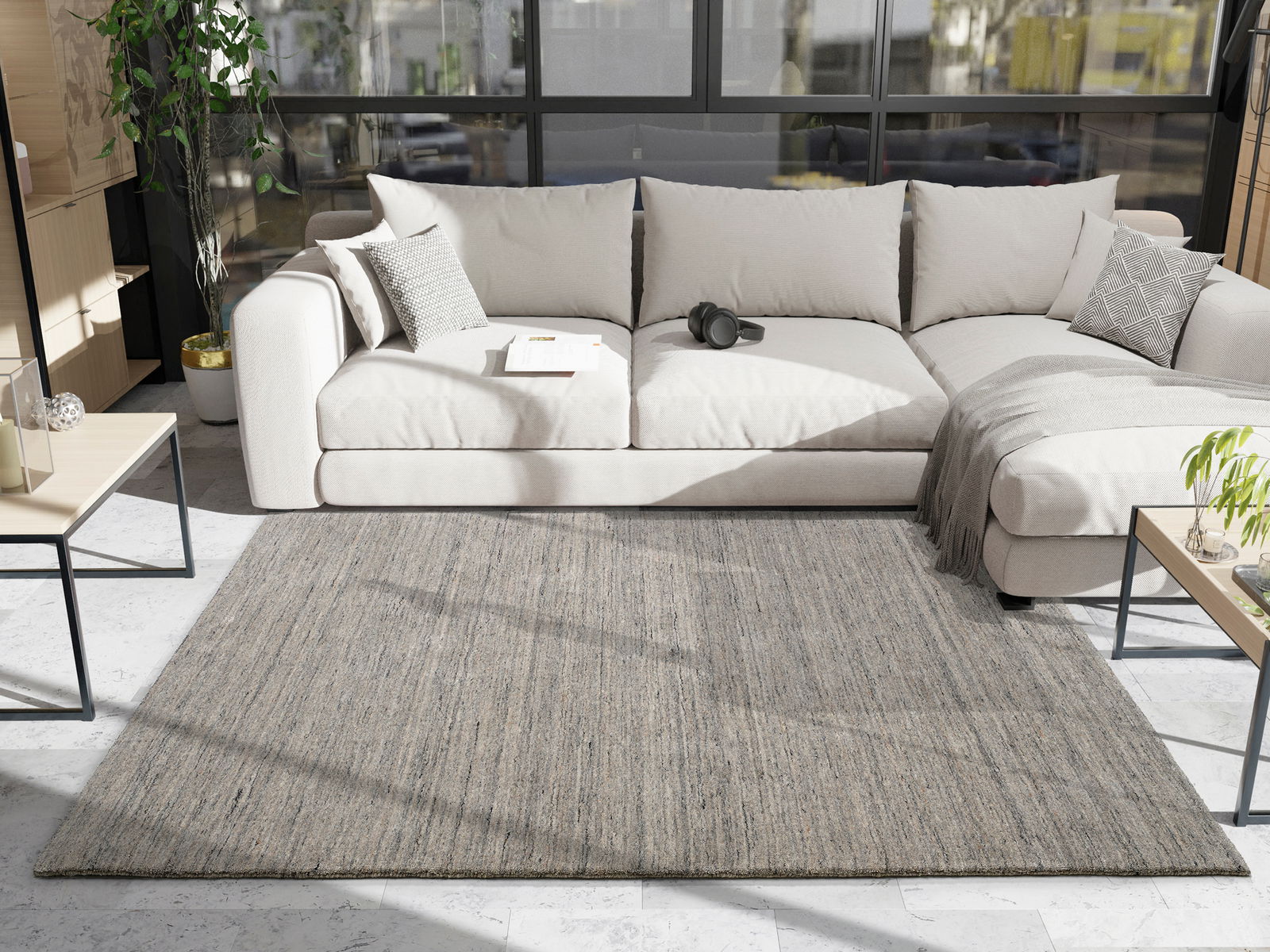 Grauer Wollteppich in einem modernen Wohnzimmer, fotografiert aus der Vogelperspektive, mit einem beigen Sofa und einem Couchtisch im Hintergrund.