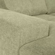 Nahaufnahme einer grünen Sofaecke mit texturierter Stoffoberfläche, Perspektive von der Seite