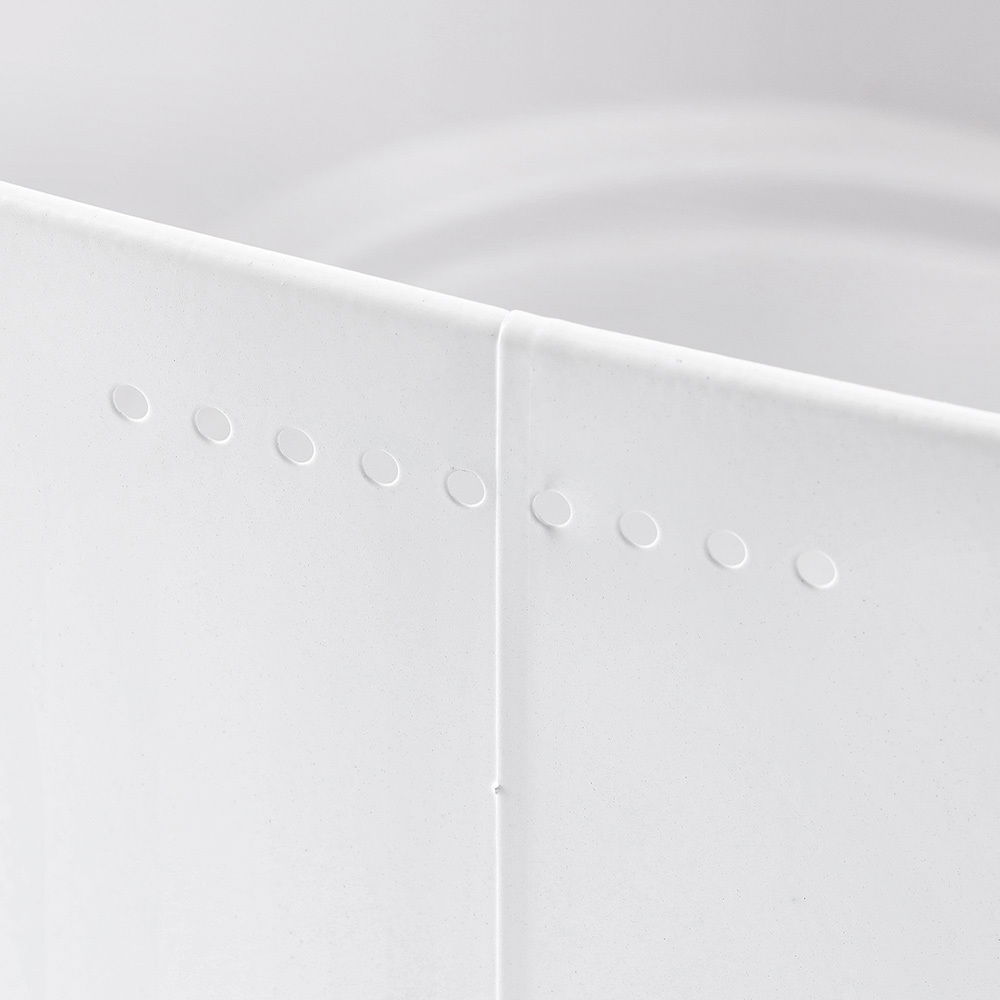 Nahaufnahme eines weißen Brotkastens mit gestanzten Löchern, seitliche Perspektive