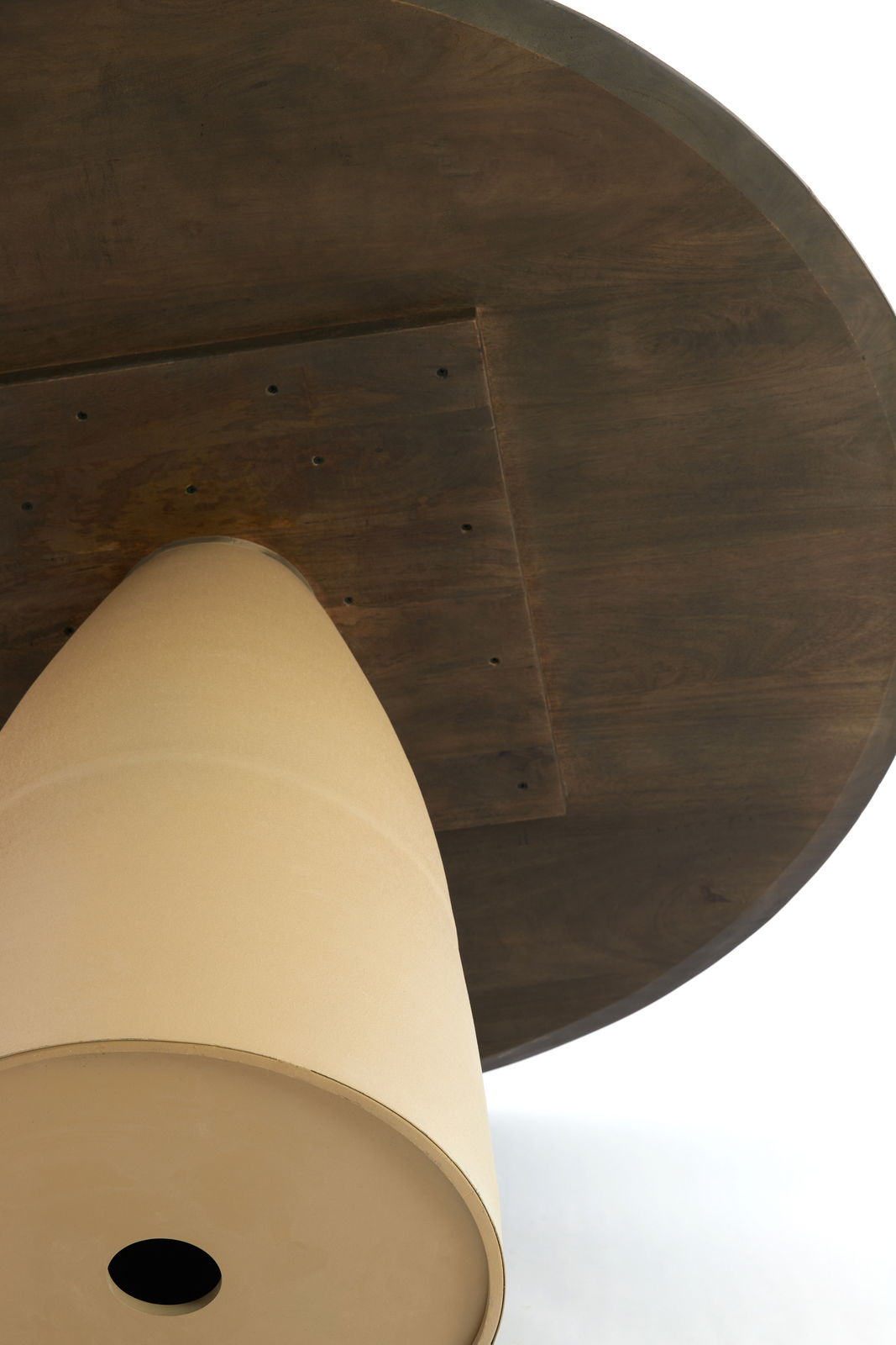 Unteransicht eines runden Esstisches mit konischem Sockel und dunkler Holzoberfläche.