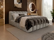 Modern gestoffeerd bed in een stijlvolle slaapkamer, zijaanzicht