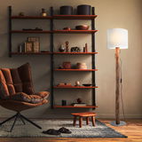 Stehleuchte mit natürlichem Holzstamm und weißem Lampenschirm, seitliche Perspektive im Wohnzimmer mit Regal und Sessel.