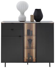 Frontansicht des Dieter Knoll Highboards RIANI in dunklem Design mit dekorativen Objekten auf der Oberseite und beleuchtetem Glaselement.