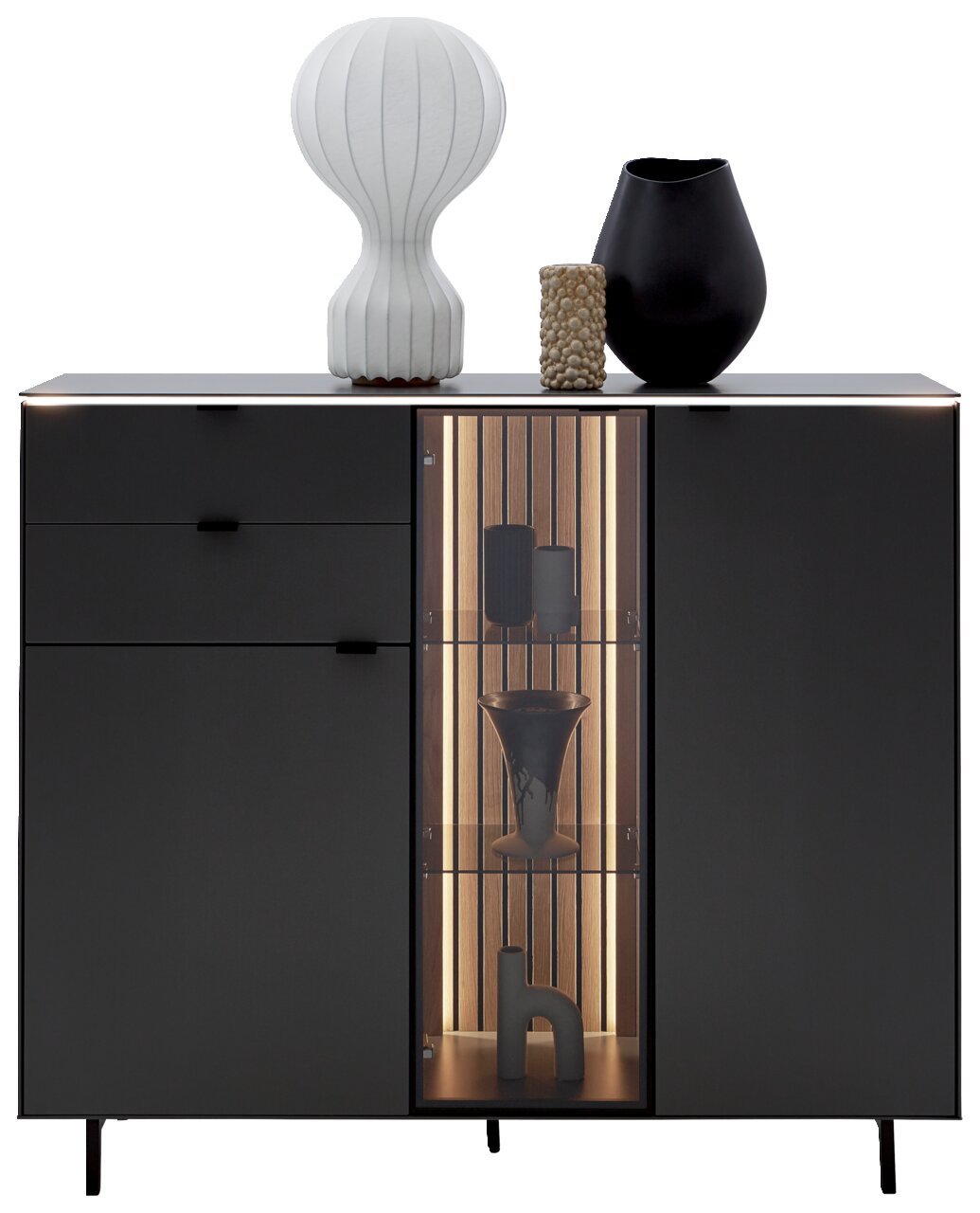 Vooraanzicht van het Dieter Knoll-highboard RIANI in een donkere uitvoering, met decoratieve voorwerpen op het bovenblad en een verlicht glazen element.