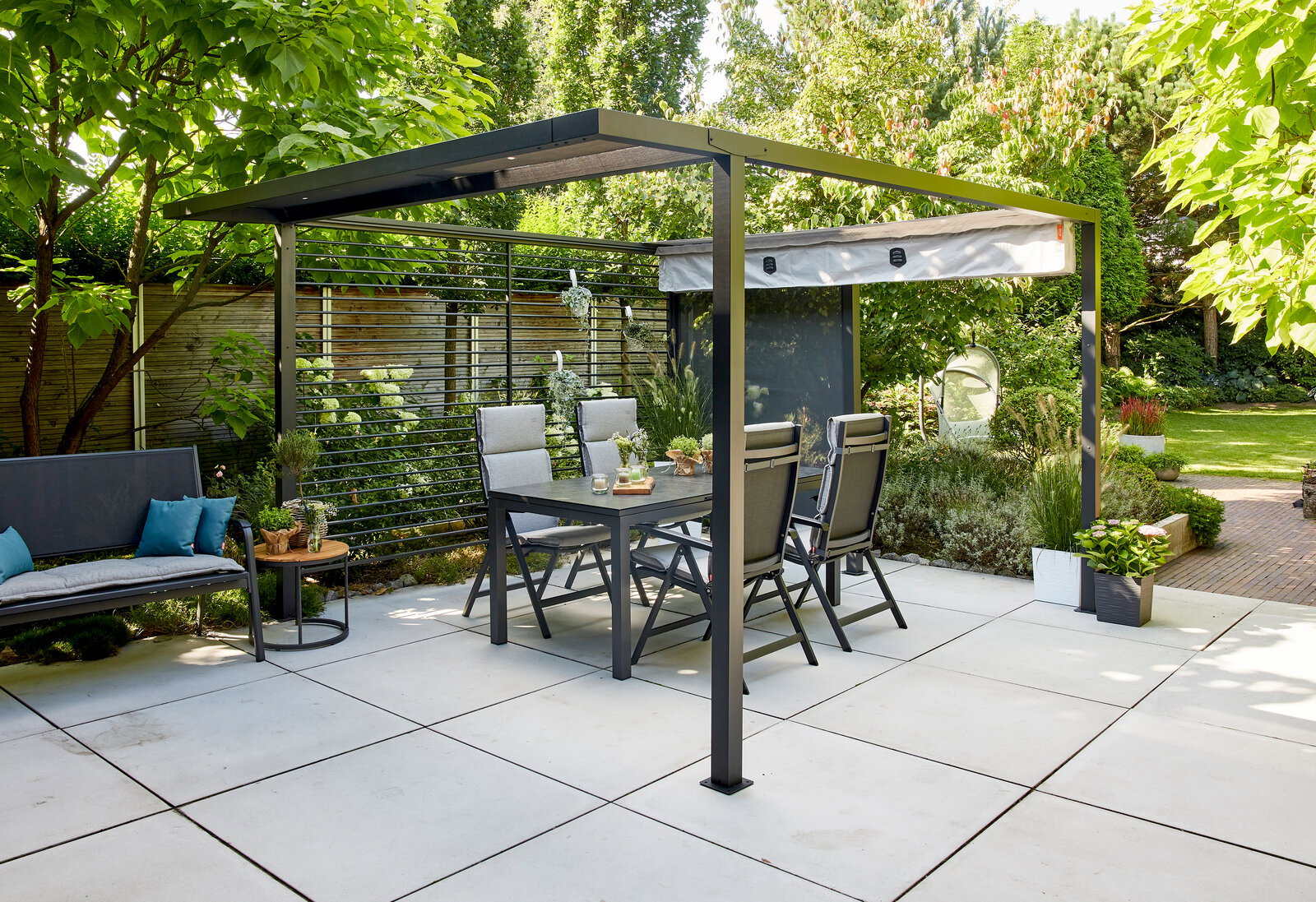 Moderne Pergola mit Faltdach und Gartenmöbeln, seitliche Perspektive