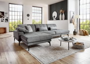 Graue Longchairkombination mit XXL-Hocker in modernem Wohnzimmer, seitliche Perspektive.
