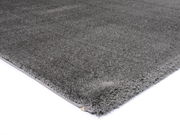 Grauer Hochflor-Teppich in Nahaufnahme, perspektivisch von der Seite fotografiert.