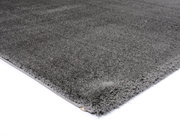 Grauer Hochflor-Teppich in Nahaufnahme, perspektivisch von der Seite fotografiert.