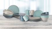 Vielseitiges Tafelservice Loft in sanften Pastelltönen, bestehend aus Tellern, Schalen und Tassen, auf einer Holzoberfläche präsentiert, seitliche Perspektive.