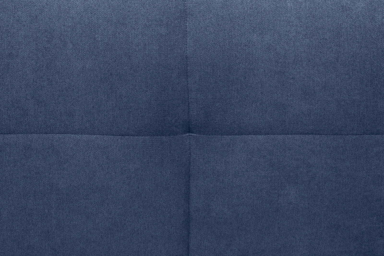 Nahaufnahme eines blauen, gepolsterten Stoffes mit quadratischem Muster, perspektivisch von oben betrachtet.