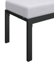 Nahaufnahme eines Gartenlounge-Sets mit schwarzem Metallrahmen und hellgrauem Polster, seitliche Perspektive.