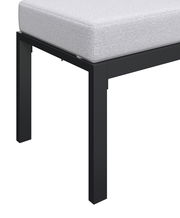 Nahaufnahme eines Gartenlounge-Sets mit schwarzem Metallrahmen und hellgrauem Polster, seitliche Perspektive.