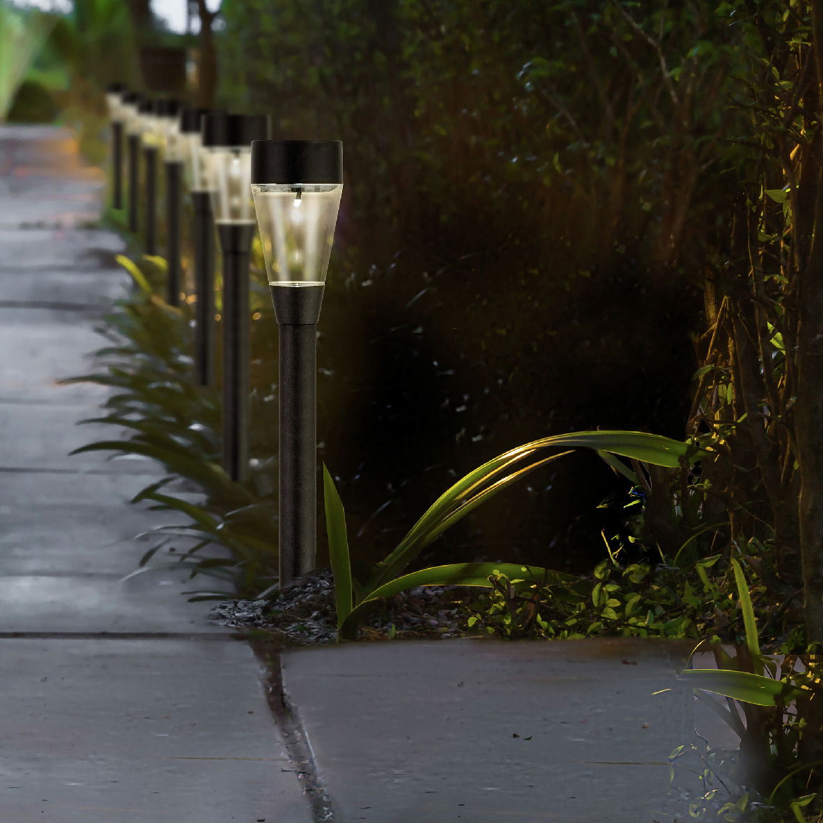Solarbetriebene Stabbeleuchtung aus Edelstahl entlang eines Gehwegs, seitliche Perspektive