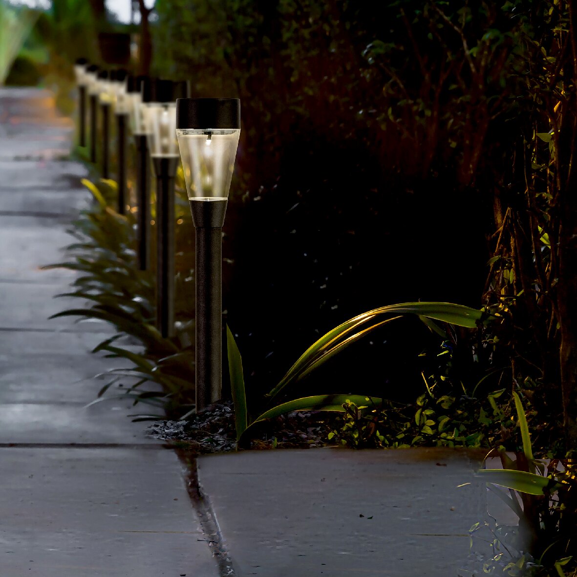 Lumineo Solarleuchte Gartenstecker 10er-Set Solarbetriebene Stabbeleuchtung aus Edelstahl entlang eines Gehwegs, seitliche Perspektive