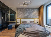 Moderne Deckenleuchte INVERTINA mit kreisförmigem Design, von unten betrachtet in einem stilvollen Schlafzimmer mit grauer Akzentwand und großen Fenstern.