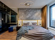 Moderne Deckenleuchte INVERTINA mit kreisförmigem Design, von unten betrachtet in einem stilvollen Schlafzimmer mit grauer Akzentwand und großen Fenstern.