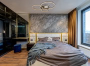 Moderne Deckenleuchte INVERTINA mit kreisförmigem Design, von unten betrachtet in einem stilvollen Schlafzimmer mit grauer Akzentwand und großen Fenstern.