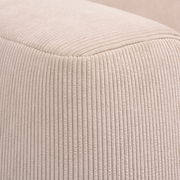 Nahaufnahme eines beigen, gerippten Stoffes eines Funktionssofas, perspektivisch von der Ecke aufgenommen.