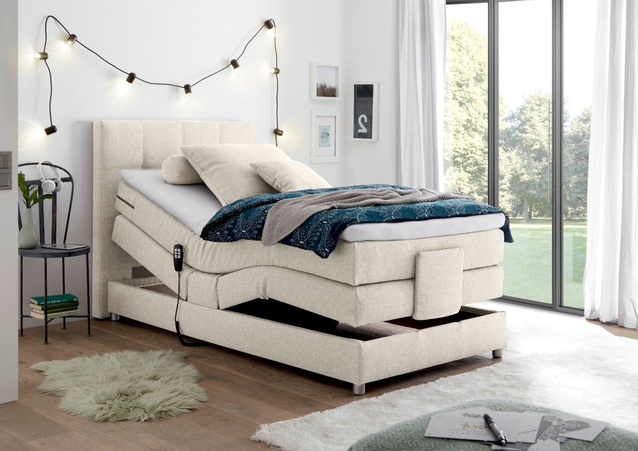 Boxspringbett in modernem Schlafzimmer, seitliche Perspektive, mit verstellbarer Matratze und gemütlicher Dekoration.