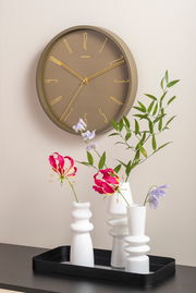 Wanduhr Belle Numbers aus Metall in Seitenansicht, mit goldenen Zeigern und Ziffern auf braunem Zifferblatt, dekoriert mit Blumen in weißen Vasen.