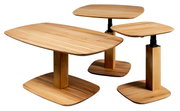 Drei moderne Holztische in verschiedenen Höhen und Größen, aus hellem Holz mit rechteckigen Tischplatten und stabilen, quadratischen Beinen. Perspektive von schräg oben.