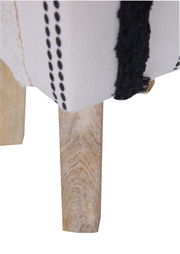 Nahaufnahme eines Hockers mit Holzbein und gestreiftem Stoffbezug, seitliche Perspektive