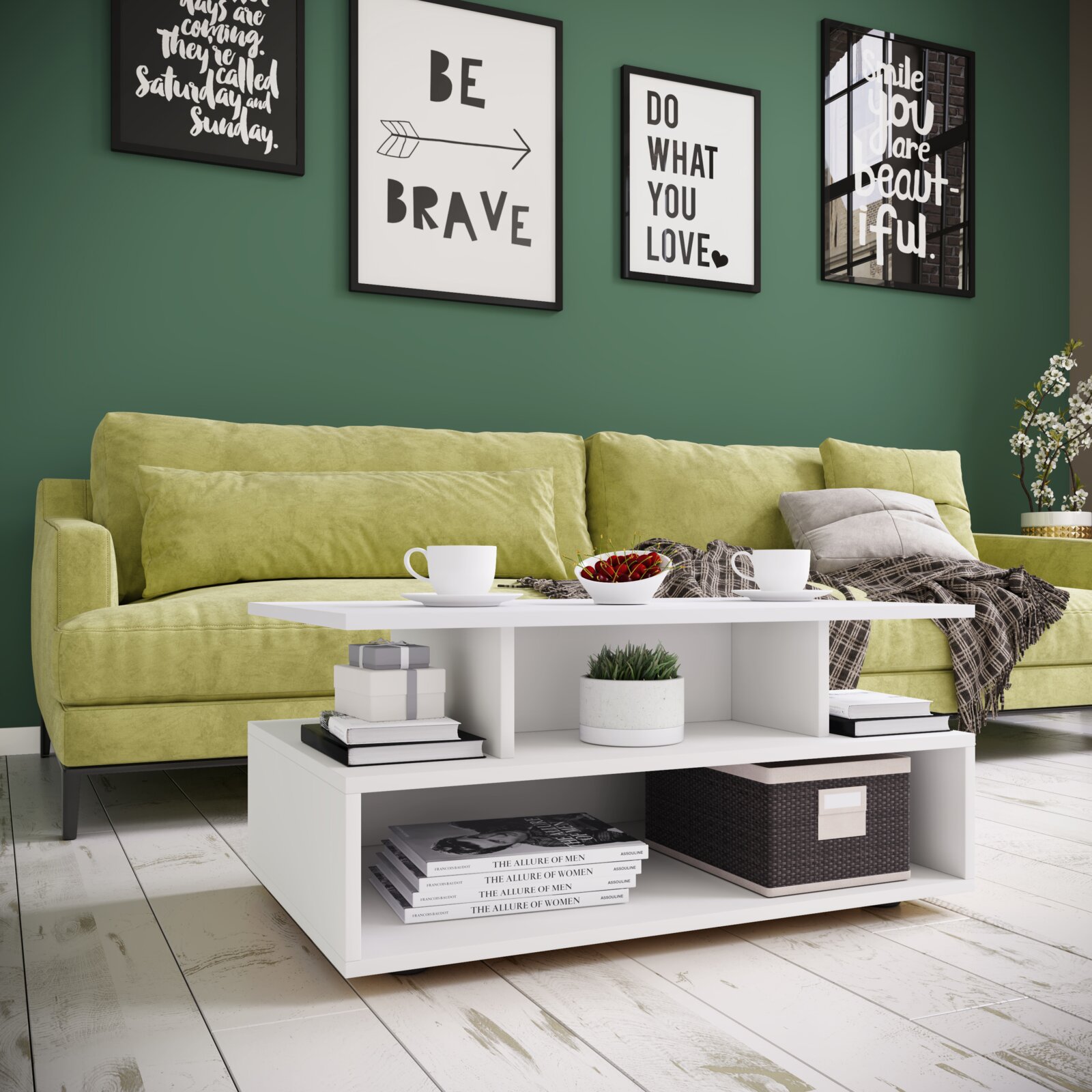 Moderner weißer Couchtisch mit Ablagefächern vor grünem Sofa im Wohnzimmer, dekoriert mit Tassen, Schale und Büchern; Perspektive: frontale Ansicht leicht von links