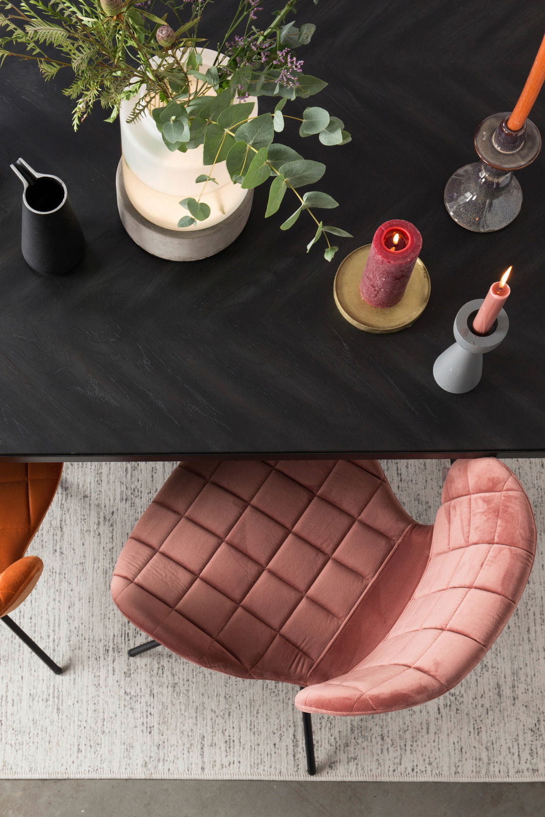 Z2 Stuhl OMG Vogelperspektive auf einen eleganten, rosafarbenen Stuhl mit gesteppter Polsterung neben einem Tisch mit Kerzen und Pflanzen.