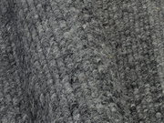 Nahaufnahme eines grauen Handweb Teppichs mit strukturierter Oberfläche, seitliche Perspektive