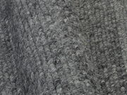 Nahaufnahme eines grauen Handweb Teppichs mit strukturierter Oberfläche, seitliche Perspektive