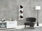 Weißes wandmontiertes Weinregal mit drei schrägen Ablagen und mehreren Weinflaschen, im Wohnzimmer an grauer Steinwand – Frontalansicht in leichter Perspektive von links.
