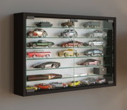 Schwarze Glasvitrine mit mehreren Glasböden, gefüllt mit Modellautos und -fahrzeugen, in schräger Frontansicht von links