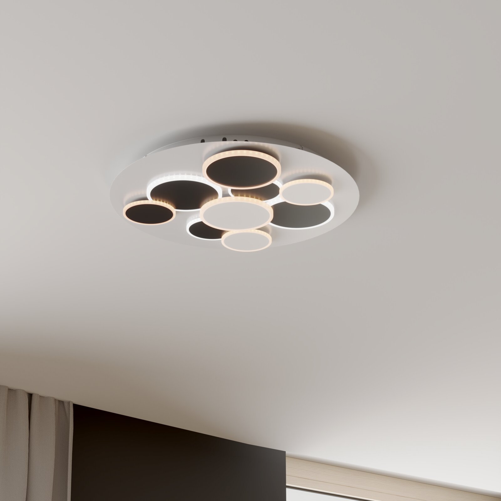 Novel LED-Deckenleuchte BLACKBURN Moderne runde LED-Deckenleuchte mit mehreren kreisförmigen Leuchtringen in Weiß und Schwarz, montiert an der Decke; Perspektive von unten leicht seitlich (Untersicht).