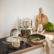 Küchenansicht mit einem sechsteiligen Topfset Twin Classic aus Edelstahl, bestehend aus Töpfen und Pfannen, auf einem Herd und einer Arbeitsplatte arrangiert.