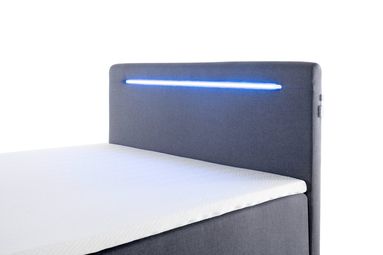 Boxbett mit grauem Kopfteil und integrierter blauer LED-Beleuchtung, seitliche Perspektive
