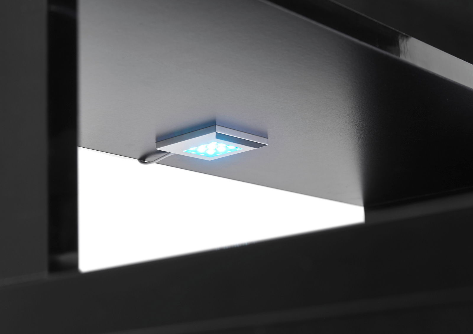 Nahaufnahme einer LED-Leuchte unter einem Gaming-Schreibtisch, von unten betrachtet.