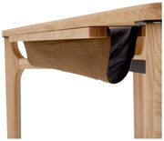 Close-up van een houten bureau met een hangende stoffen tas onder het tafelblad, gezien vanaf de zijkant