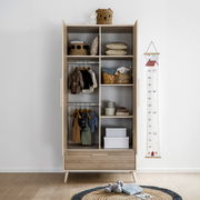 Offener Kleiderschrank mit zwei Türen und einer Schublade, gefüllt mit Kinderkleidung und Accessoires, aus frontaler Perspektive.