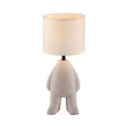 Moderne tafellamp met een cilindervormige, witte stoffen kap en een sculpturale, beige voet in de vorm van een figuur, van voren gezien in een licht bovenaanzicht