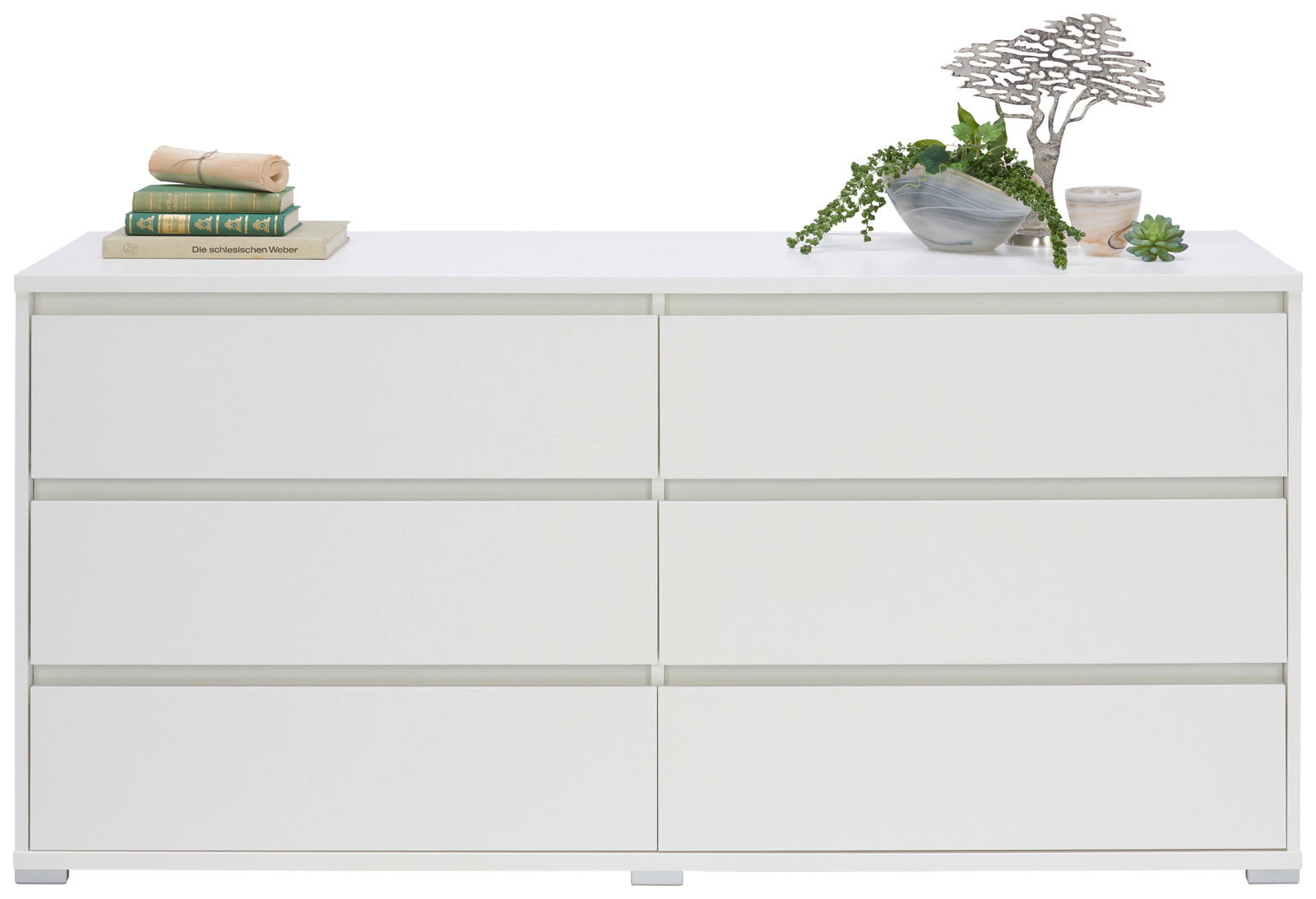 Weißes XL-Sideboard mit sechs Schubladen, dekoriert mit Büchern und Pflanzen, Frontalansicht.