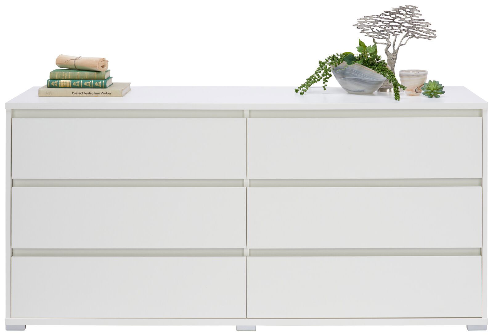 Weißes XL-Sideboard mit sechs Schubladen, dekoriert mit Büchern und Pflanzen, Frontalansicht.