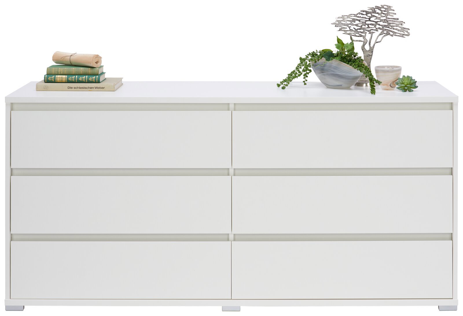 Weißes XL-Sideboard mit sechs Schubladen, dekoriert mit Büchern und Pflanzen, Frontalansicht.