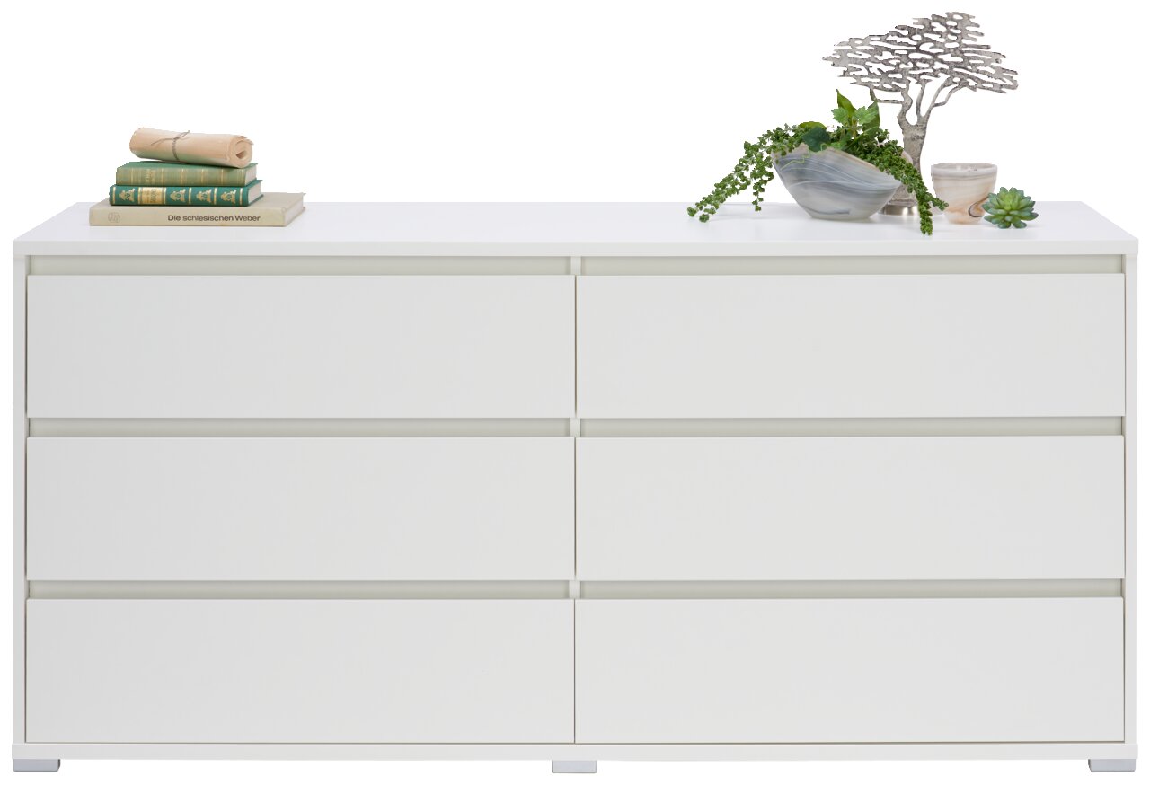 Weißes XL-Sideboard mit sechs Schubladen, dekoriert mit Büchern und Pflanzen, Frontalansicht.