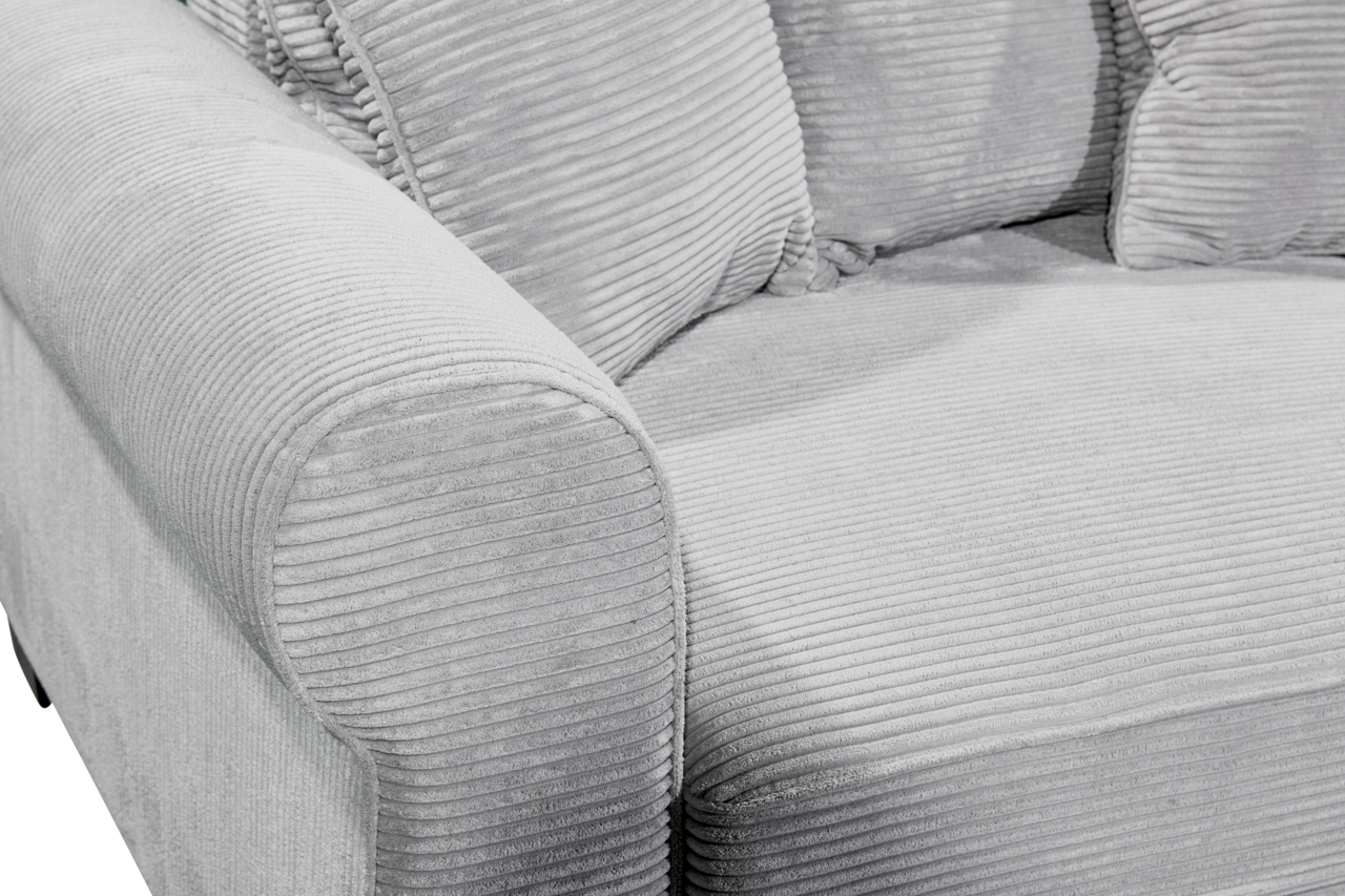 Nahaufnahme eines grauen Funktionssofas mit geripptem Stoffbezug, seitliche Perspektive auf die Armlehne und Sitzfläche.