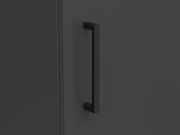 Nahaufnahme eines schwarzen Griffs an einem dunklen Mehrzweckschrank, seitliche Perspektive
