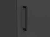 Nahaufnahme eines schwarzen Griffs an einem dunklen Mehrzweckschrank, seitliche Perspektive
