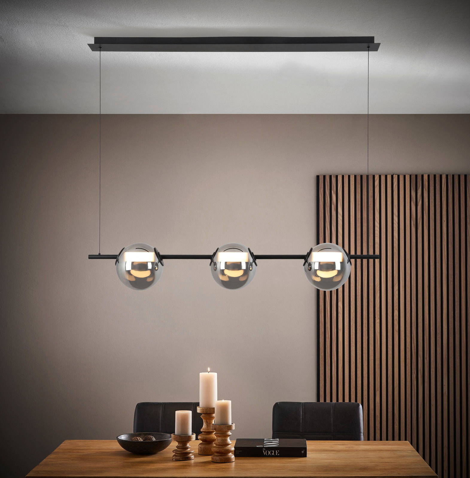 Moderne LED-Hängeleuchte SECCO mit drei kugelförmigen Leuchten über einem Esstisch, seitliche Perspektive.