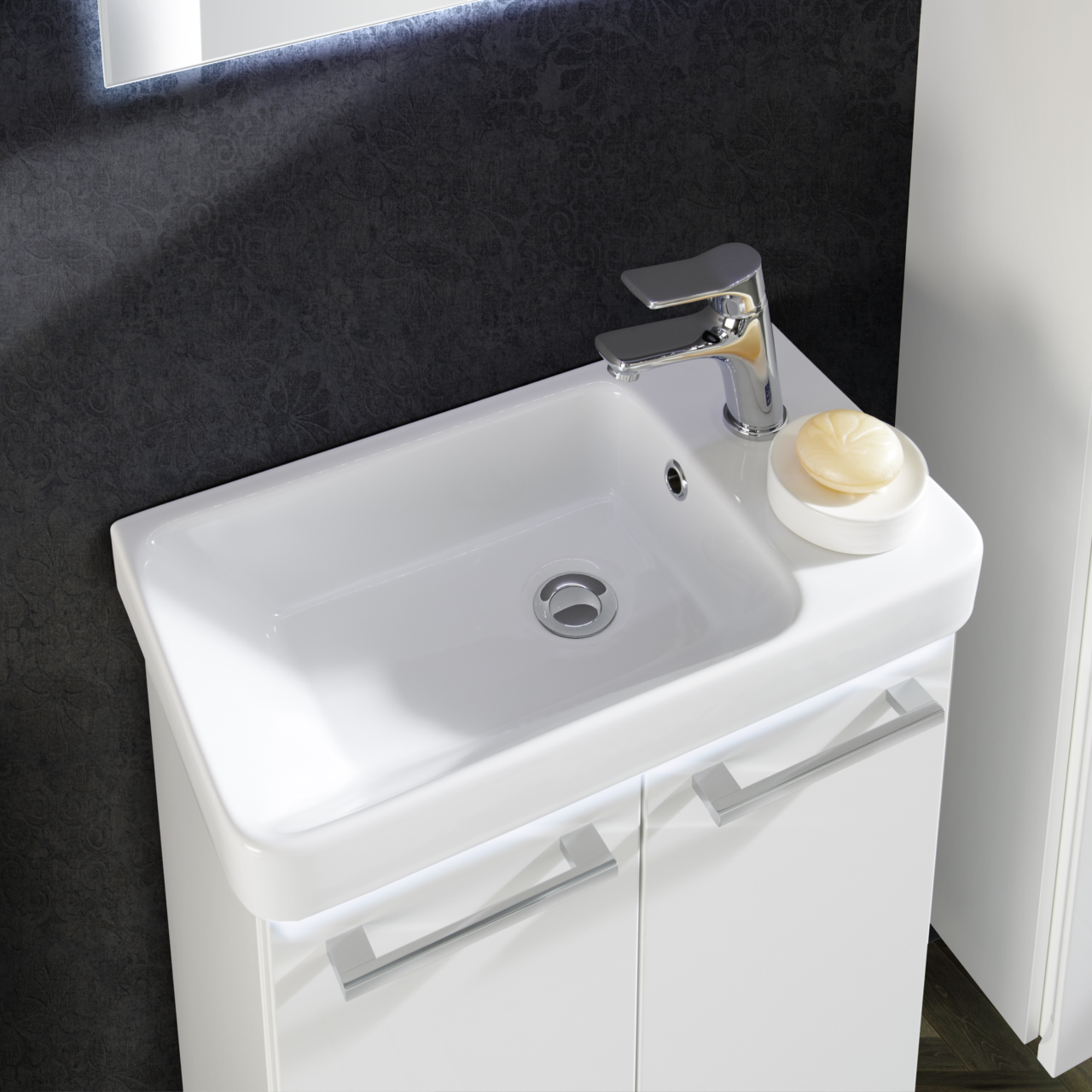 Moderner Waschtisch mit glänzendem Wasserhahn und Seifenschale, aus der Vogelperspektive fotografiert.