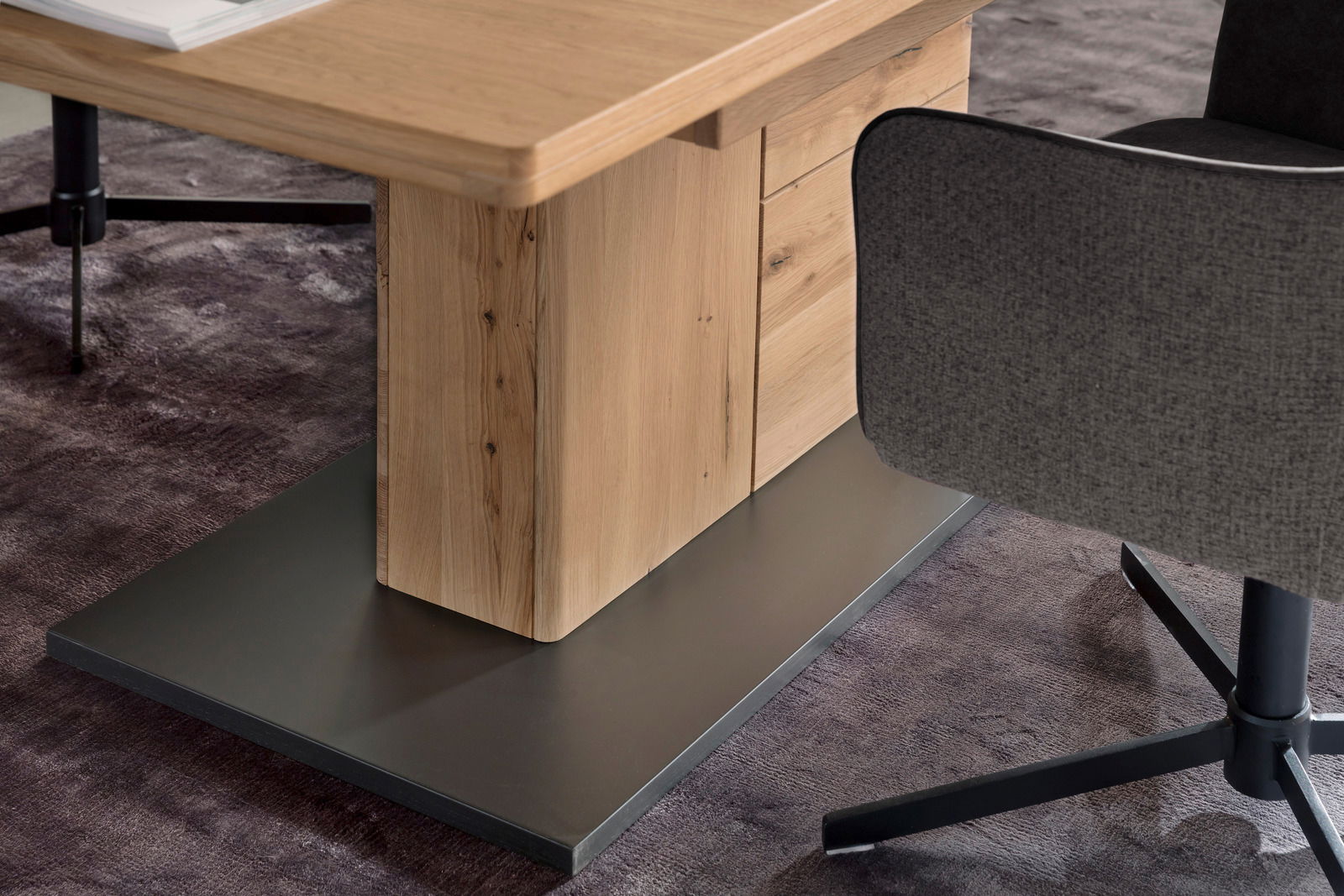 Nahaufnahme eines modernen Esstisches aus Holz mit stabiler Basis, seitliche Perspektive